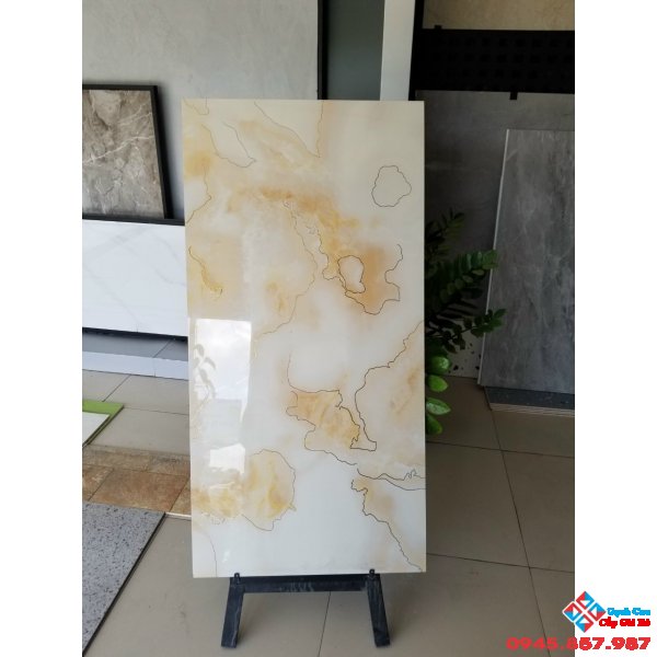 Đá bóng kiếng 60x120 lót nền khắc kim vàng